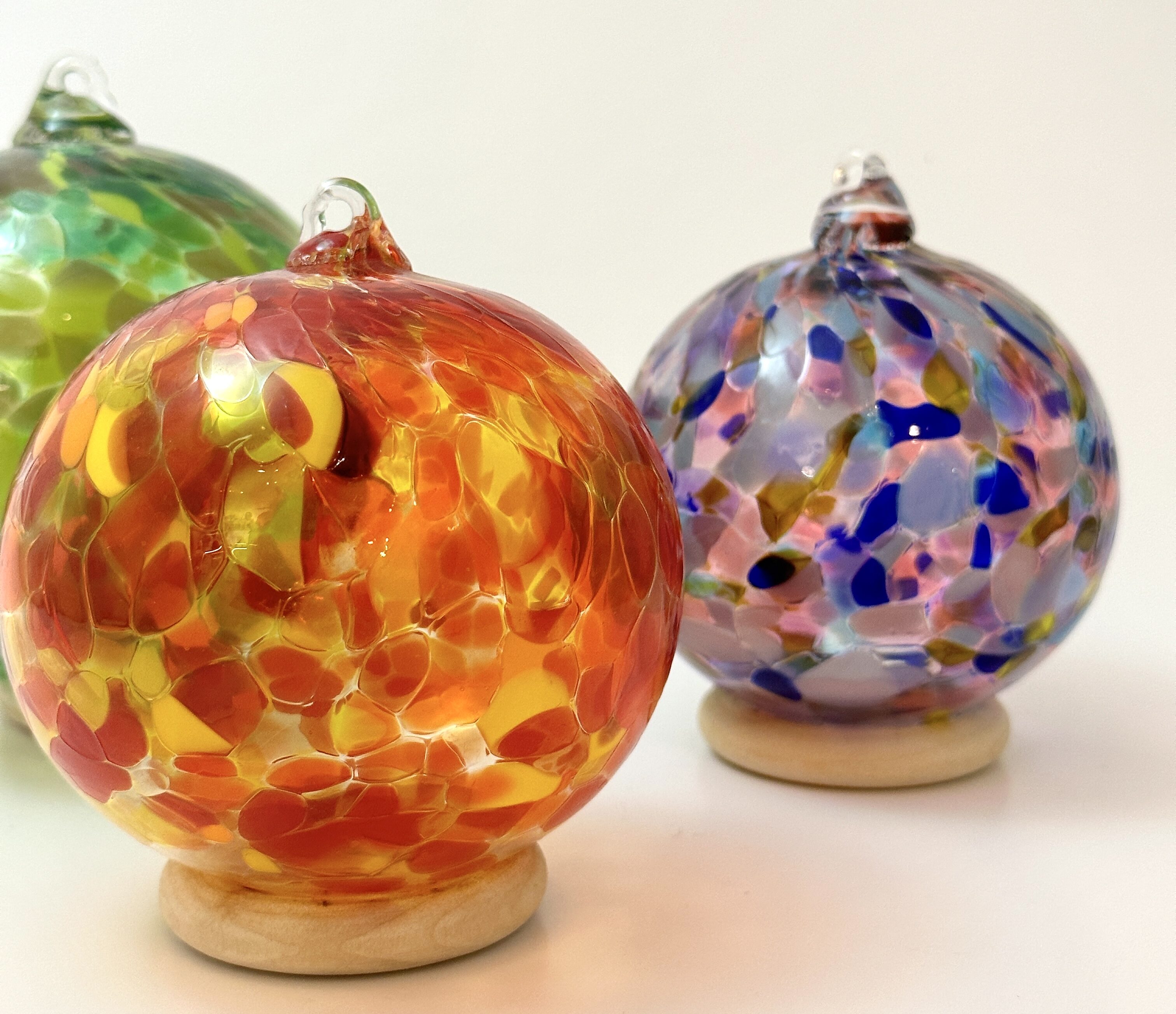 3 blown glass ornaments artfully arranged on a neutral background